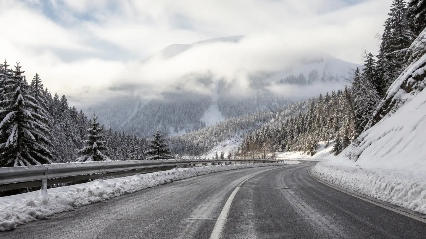 Pusta odśnieżona droga w alpejskiej dolinie z mokrym asfaltem i śnieżnymi poboczami - Nokian Snowproof 2 na śnieg, błoto pośniegowe i deszcz